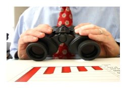 Man holding binoculars in front of a graph.