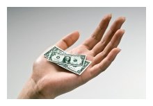 Hand holding shrunken dollar bills